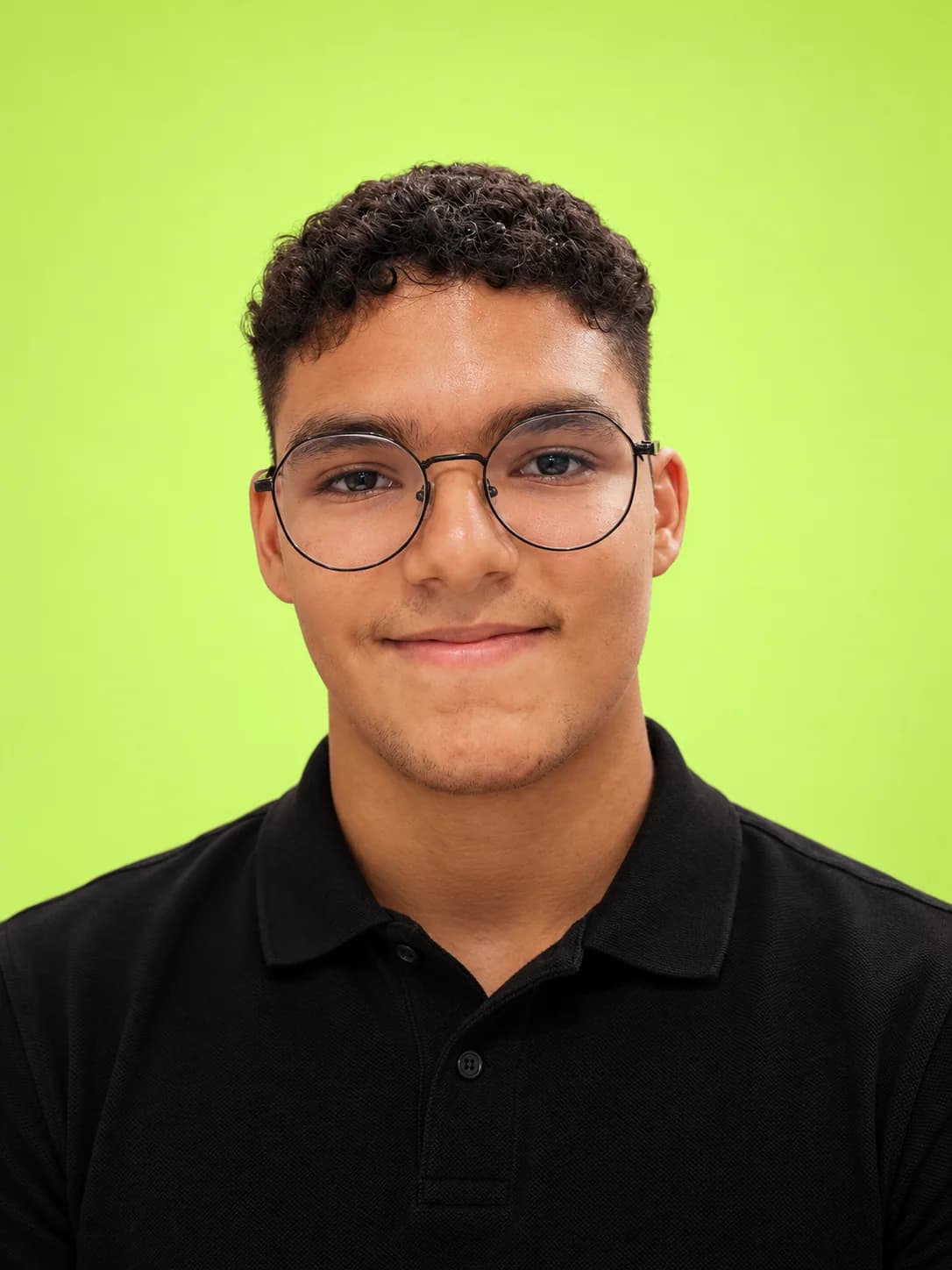 Retrato de Anthony Gabriell, de óculos e camisa polo preta, sobre fundo verde-lima